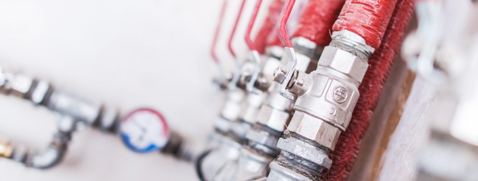 Home Plumbing System Closeup Photo. Red Isolated Pipes with Ball Valves. Residential Water Supply System.